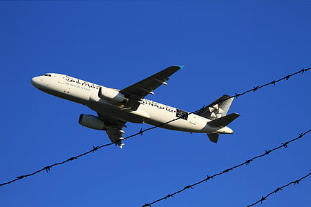 low angle photo of airplane flying over barb wires thumbnail