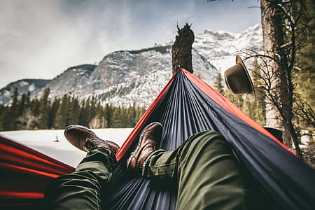 man in black jeans resting on a hammock outdoors thumbnail