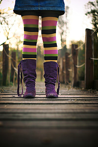 person wearing purple boots an stripe pants standing on dock thumbnail