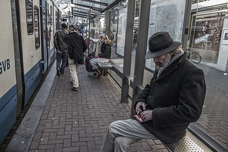man sitting on bench of train station thumbnail