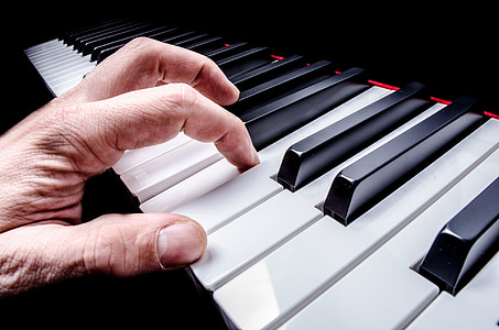 person's hand on black piano thumbnail