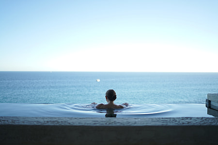 woman on body of water near blue ocean water during daytime thumbnail