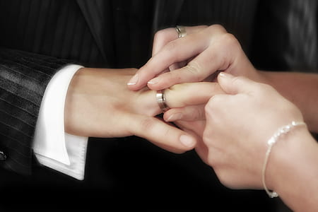 woman putting ring on man's finger thumbnail