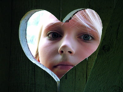 closeup photo of girl peeping on heart hole thumbnail