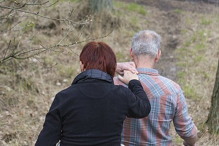 two person walking near trees thumbnail