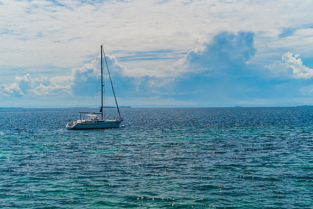 white sailboat on body of water under cloudy day thumbnail