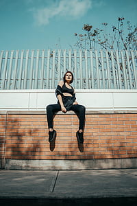 woman in black sports bra sitting on concrete bricks thumbnail