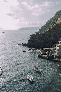 cliff on shore under white clouds during daytime thumbnail