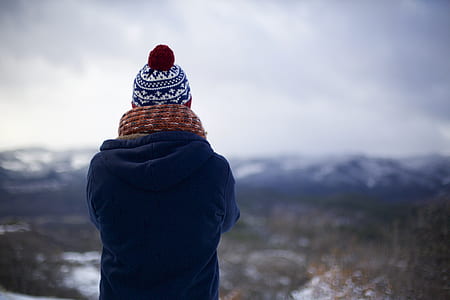 person in blue jacket, brown, scarf, and black and white bobble hat thumbnail