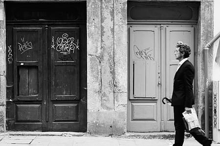 Greyscale Photo of Man Walking on Street thumbnail