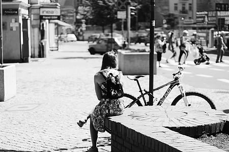 Grayscale Photo of Woman Sitting Near Bicycle thumbnail