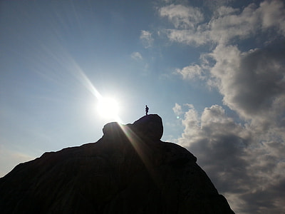 silhouette photography of person on top of hill at daytime thumbnail