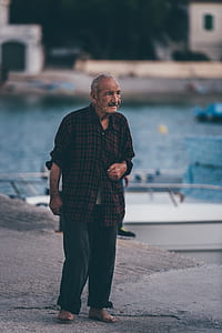 shallow focus photography of man standing near body of water thumbnail