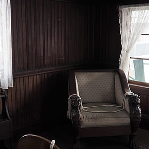 brown wooden armchair near window thumbnail