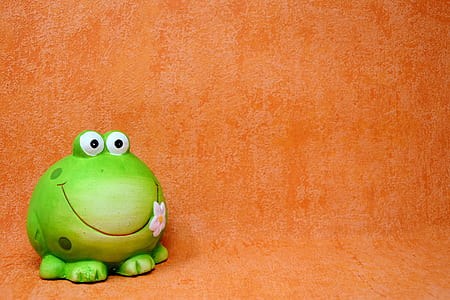 green ceramic frog table decor on top of orange surface thumbnail