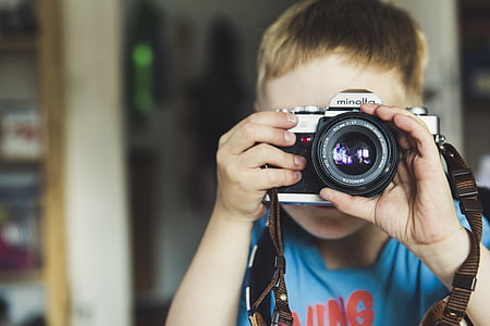 boy holding black Minolta camera body thumbnail