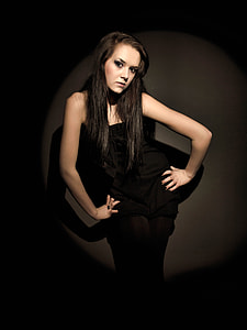woman in black strapless dress standing near wall thumbnail