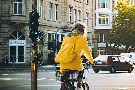Woman Wearing Yellow Hooded Coat Riding Bicycle thumbnail