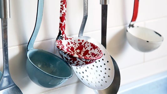gray, red, and white ladles hanged near white wall thumbnail