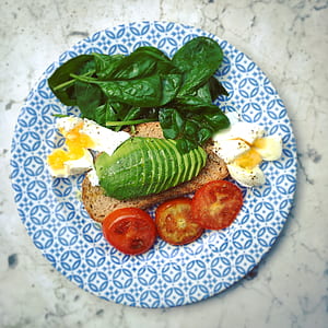 slice tomato, green spinach, toasted bread and sauce on top of blue and white ceramic plate thumbnail