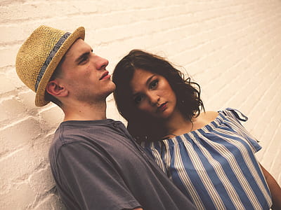 man and woman leaning on wall while taking photo thumbnail