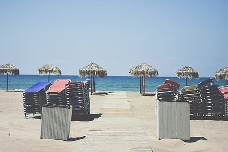brown beach umbrellas under blue sky during daytime thumbnail