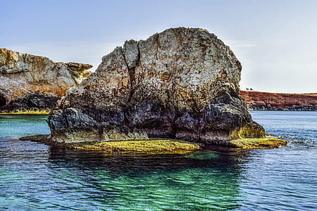 islet on calm body of water thumbnail
