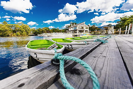 green-and-white docked boats during daytime thumbnail