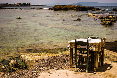 brown wooden table and chair near seashore thumbnail
