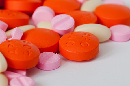 assorted-color medicine pills scattered on white panel thumbnail