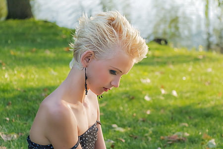girl wearing black spaghetti strap top lying on green grass thumbnail