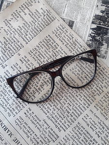 black framed Wayfarer-style sunglasses on top of newspaper thumbnail