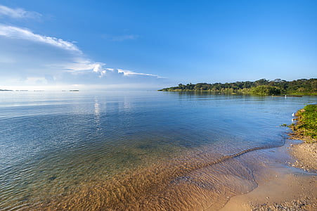 landscape photography of blue ocean near green island under clear blue sky thumbnail