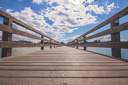 brown wooden dock under cloudy blue sky thumbnail