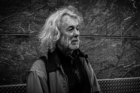 man standing near grey wall outdoors thumbnail