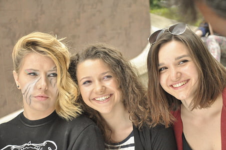 three women standing beside wall thumbnail