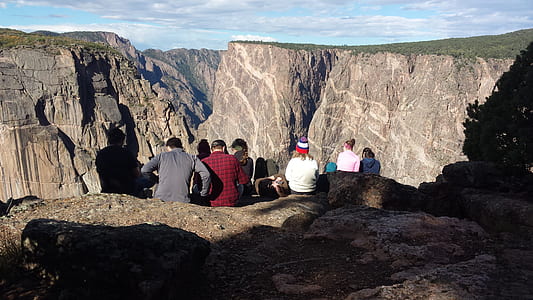 group of people sitting on cliff during daytme thumbnail