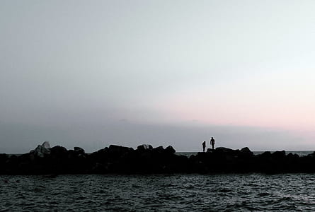 silhouette of two persons beside body of water thumbnail