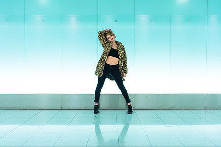 Woman wearing a coat standing by a blue wall background thumbnail