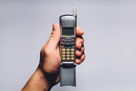 person holding gray candybar phone with antenna thumbnail