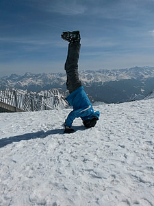 man posing up side down on snow covered land thumbnail