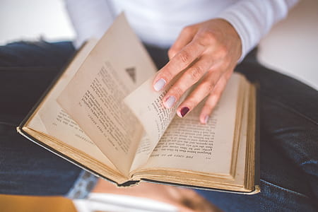 Girl thumbs through the old book thumbnail