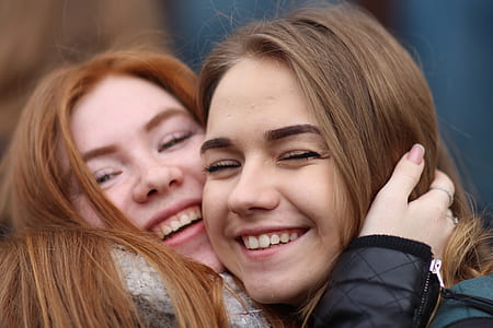 two woman smiling while hugging thumbnail