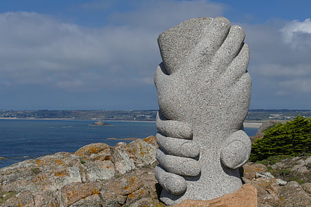 gray concrete two hands statue near sea at daytime thumbnail