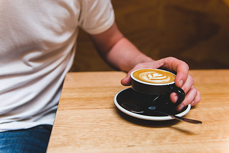 person holding teacup filled of coffee thumbnail