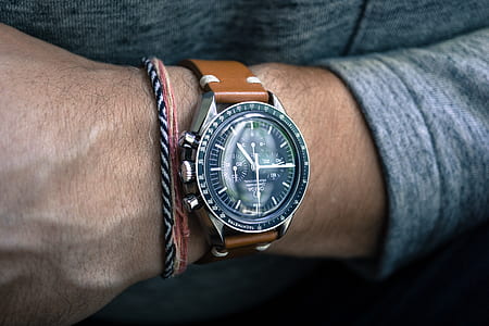person wearing round silver-colored chronograph watch thumbnail