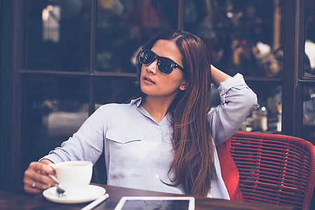 woman holding her hair while sitting on chair thumbnail