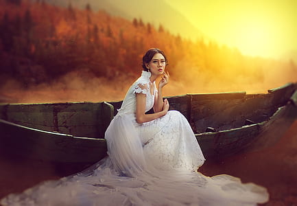 woman in white wedding dress beside canoe thumbnail