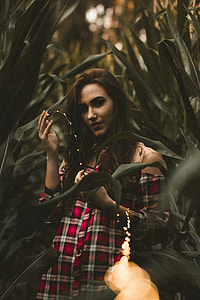 woman posing near green leafed plants photo thumbnail