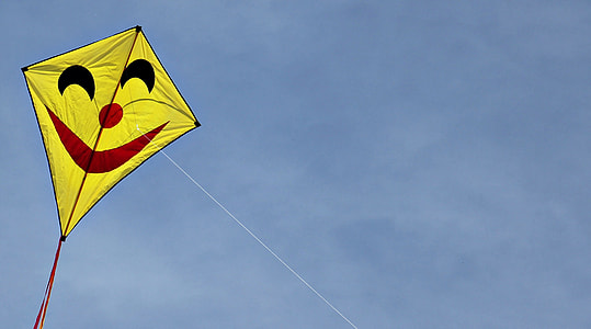 yellow and red kite under blue sky during daytime thumbnail